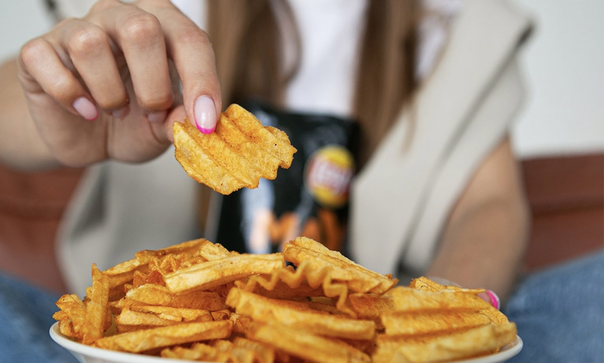 Hand picking up Lay's from a bowl